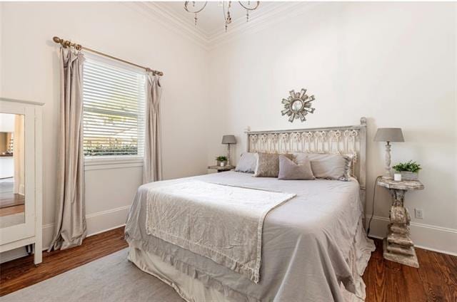 bedroom featuring an inviting chandelier, ornamental molding, and dark hardwood / wood-style floors