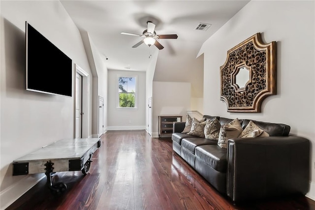 living room with ceiling fan, vaulted ceiling, and dark wood-type flooring