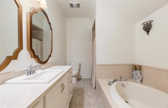 bathroom featuring tiled tub, vanity, lofted ceiling, tile patterned flooring, and toilet