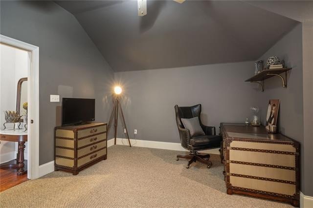 carpeted office with ceiling fan and lofted ceiling