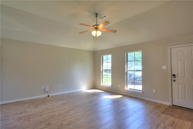 empty room featuring ceiling fan, light wood-type flooring, and lofted ceiling