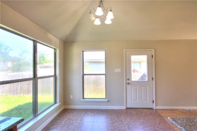 interior space with an inviting chandelier, vaulted ceiling, and tile patterned floors