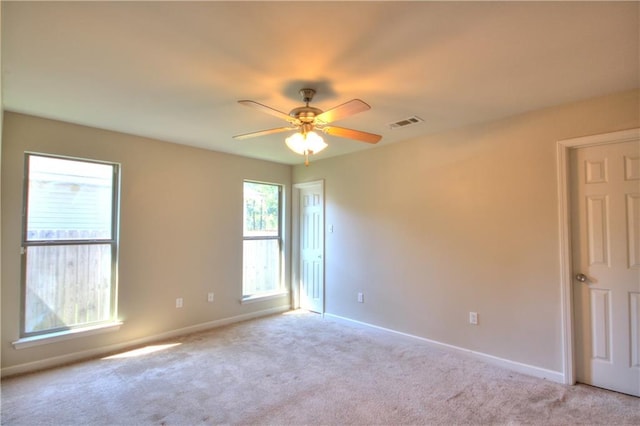 spare room featuring ceiling fan and light colored carpet