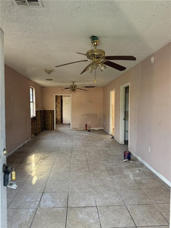 empty room featuring ceiling fan and a textured ceiling