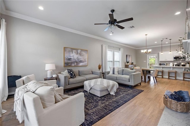 living room featuring crown molding, ceiling fan with notable chandelier, and light hardwood / wood-style flooring