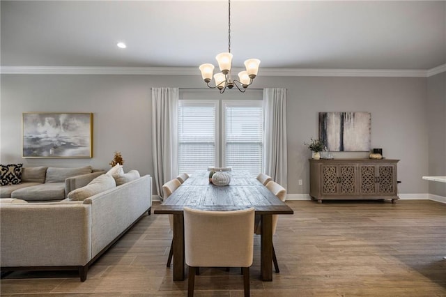 dining space with light wood-type flooring, crown molding, and an inviting chandelier