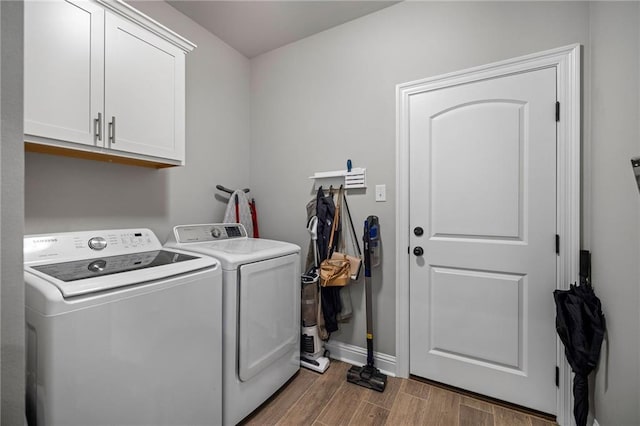 laundry room featuring separate washer and dryer, cabinets, and dark hardwood / wood-style flooring