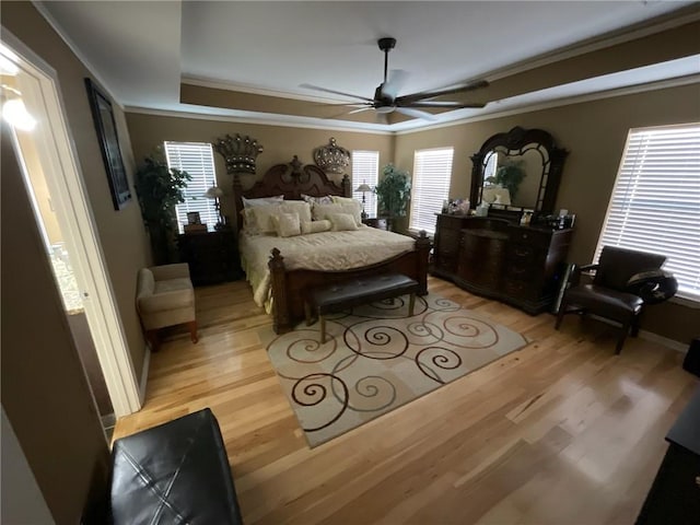 bedroom with crown molding, light hardwood / wood-style floors, and ceiling fan