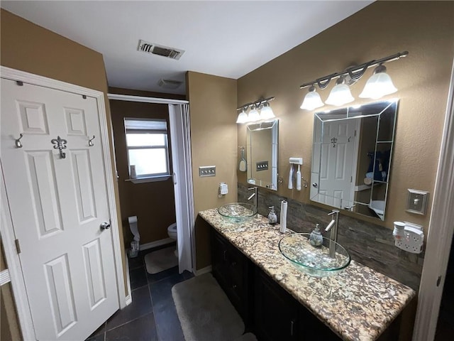 bathroom with tile patterned floors, vanity, and toilet