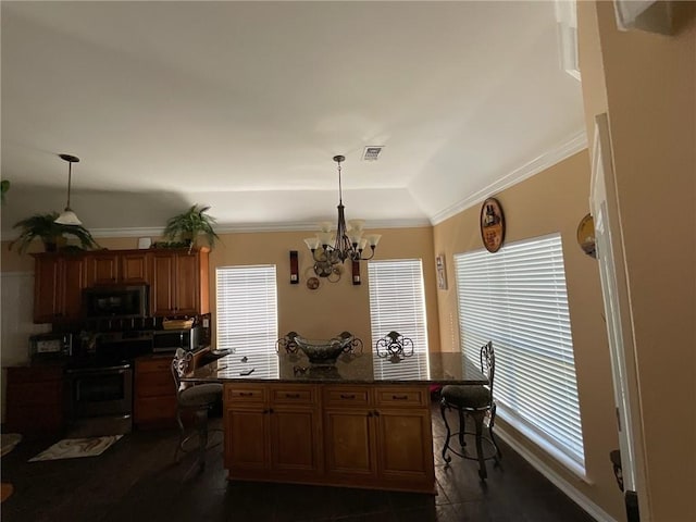 kitchen with an inviting chandelier, stainless steel appliances, hanging light fixtures, and a kitchen island