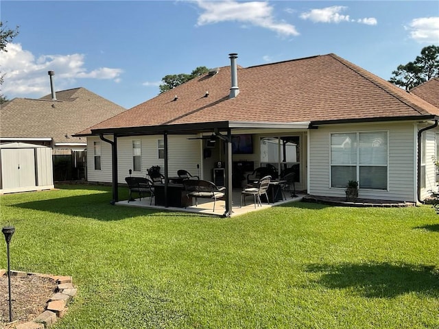 back of house featuring ceiling fan, a lawn, a storage unit, and a patio area