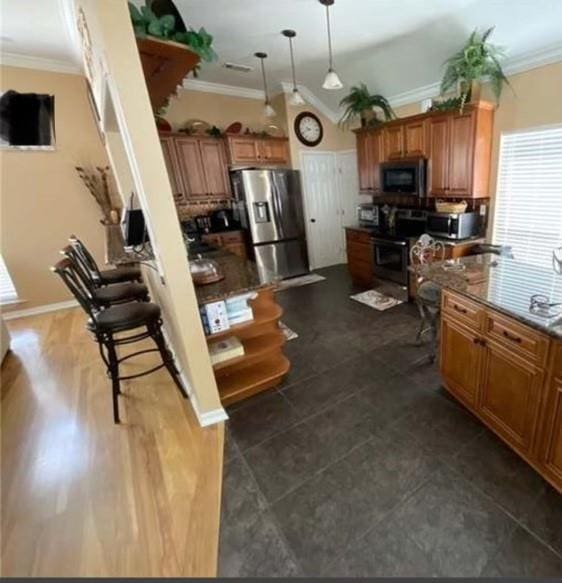 kitchen with stainless steel appliances, hanging light fixtures, and ornamental molding