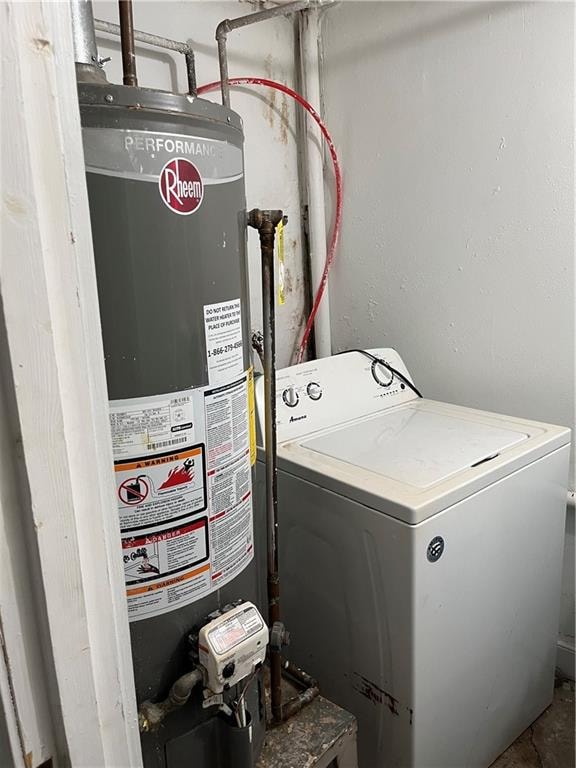 clothes washing area featuring water heater and washer / clothes dryer