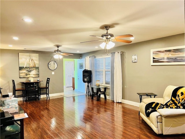 living area with dark hardwood / wood-style floors and ceiling fan