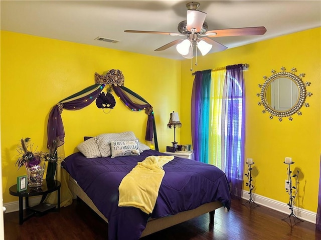 bedroom featuring ceiling fan, dark hardwood / wood-style flooring, and multiple windows