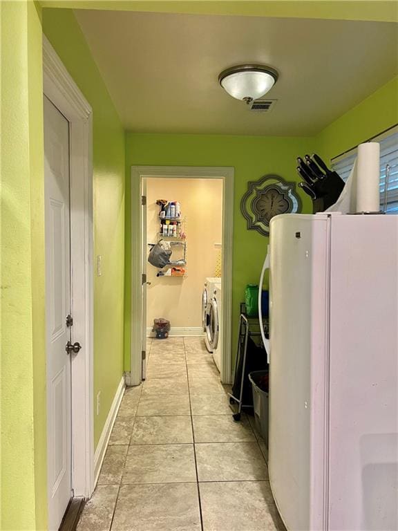 laundry room featuring light tile patterned floors and washing machine and dryer