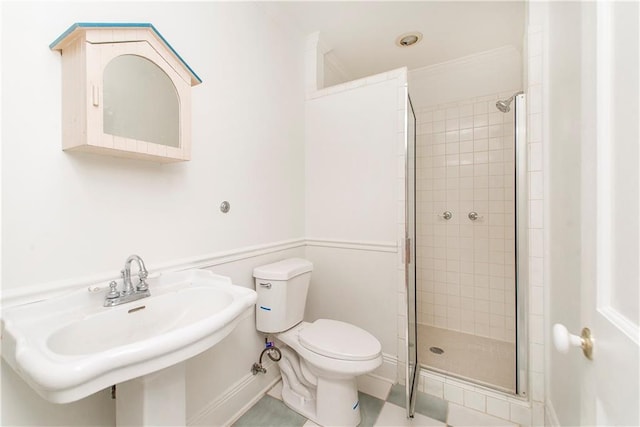 bathroom featuring sink, tile patterned floors, a shower with shower door, ornamental molding, and toilet