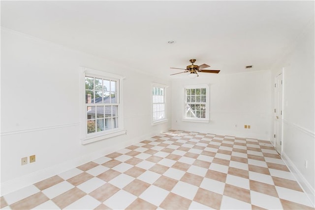 empty room with ceiling fan and a wealth of natural light