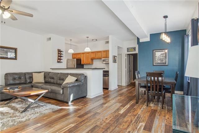 living room with ceiling fan and dark hardwood / wood-style flooring