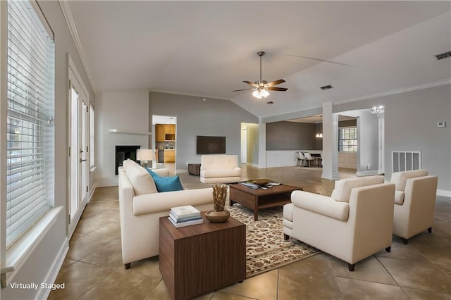 tiled living room featuring a large fireplace, vaulted ceiling, ceiling fan, and crown molding