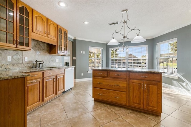 kitchen with hanging light fixtures, light stone counters, a notable chandelier, white dishwasher, and decorative backsplash