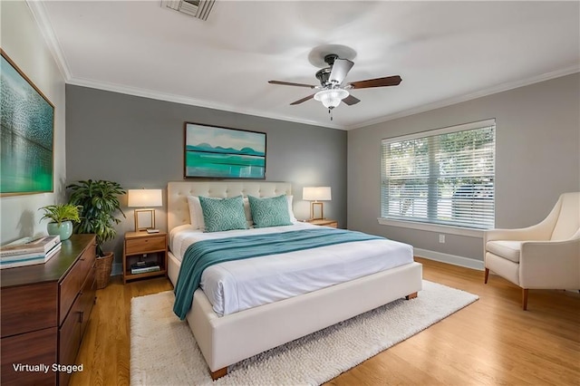 bedroom featuring ceiling fan, light hardwood / wood-style floors, and crown molding