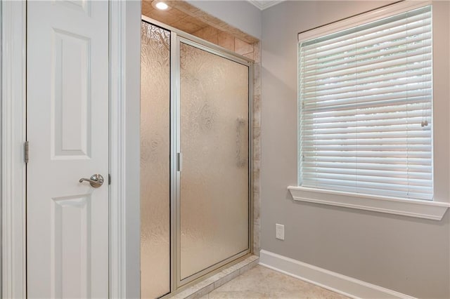 bathroom featuring tile patterned flooring, an enclosed shower, and a healthy amount of sunlight