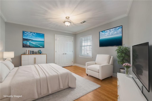 bedroom featuring a closet, ornamental molding, and light hardwood / wood-style flooring