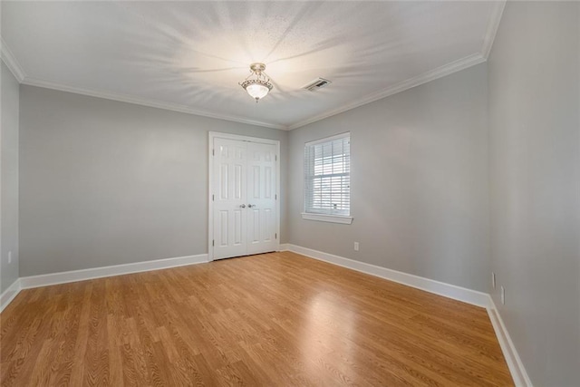 spare room featuring light hardwood / wood-style flooring and ornamental molding