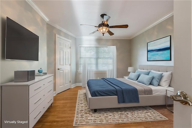 bedroom with ceiling fan, crown molding, and light wood-type flooring