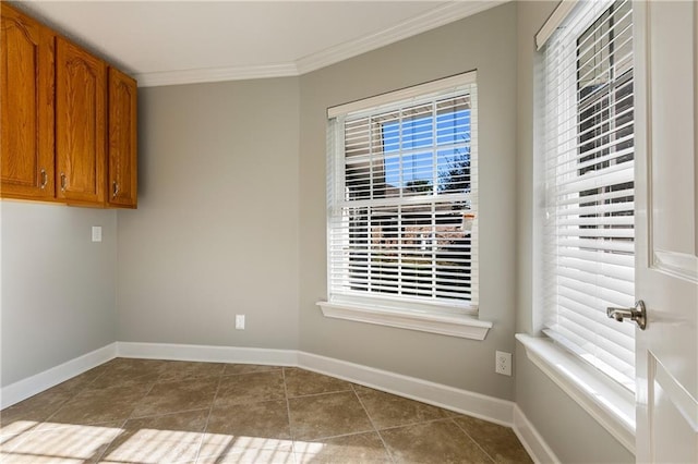 interior space with tile patterned floors, a wealth of natural light, and ornamental molding