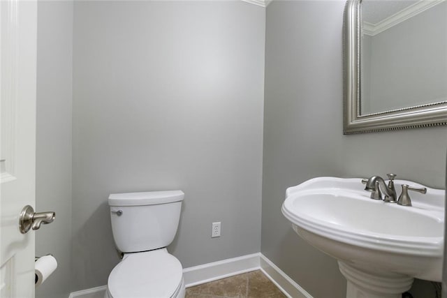 bathroom with tile patterned flooring, toilet, crown molding, and sink