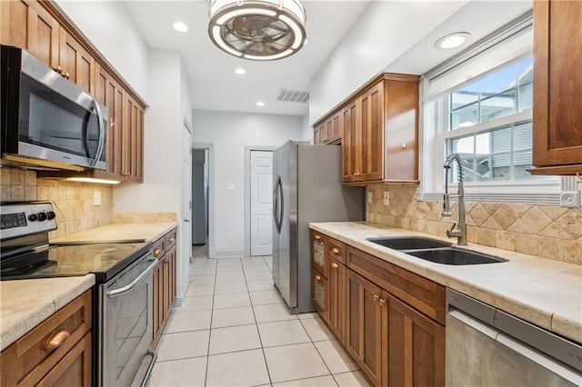 kitchen featuring backsplash, appliances with stainless steel finishes, light tile patterned flooring, and sink