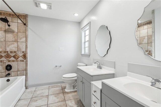 full bathroom with tiled shower / bath, vanity, toilet, and tile patterned floors