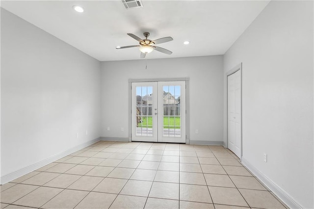 tiled empty room featuring french doors and ceiling fan