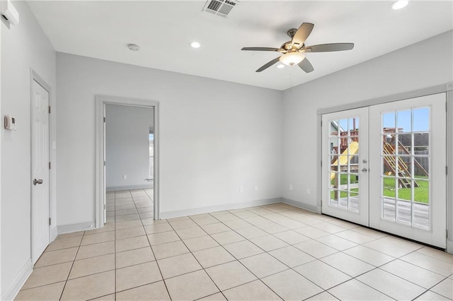 tiled spare room featuring ceiling fan and french doors