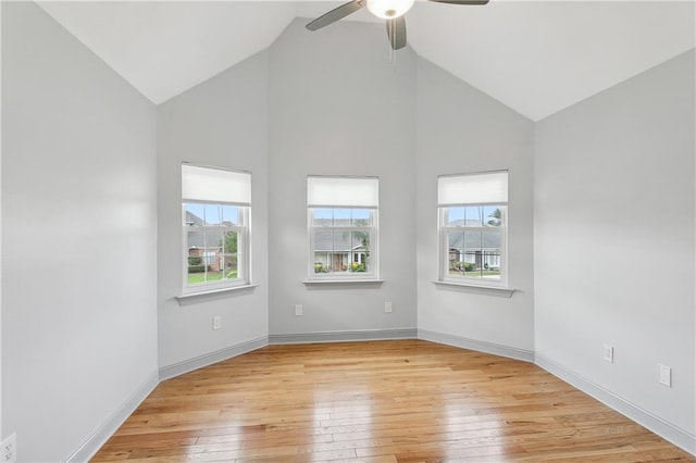 spare room with light wood-type flooring, ceiling fan, and high vaulted ceiling