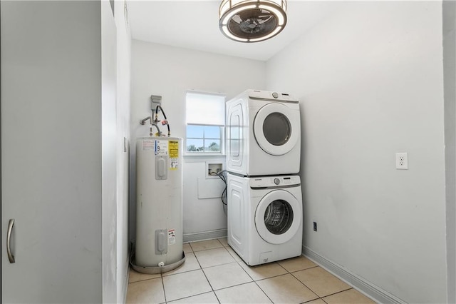 laundry area with electric water heater, light tile patterned floors, and stacked washing maching and dryer