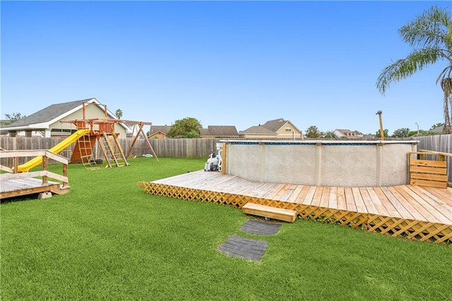 view of yard with a playground and a swimming pool side deck