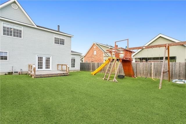 exterior space with a playground, a wooden deck, and a lawn