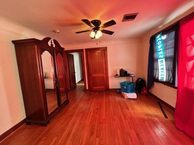 interior space with baseboards, wood finished floors, and visible vents