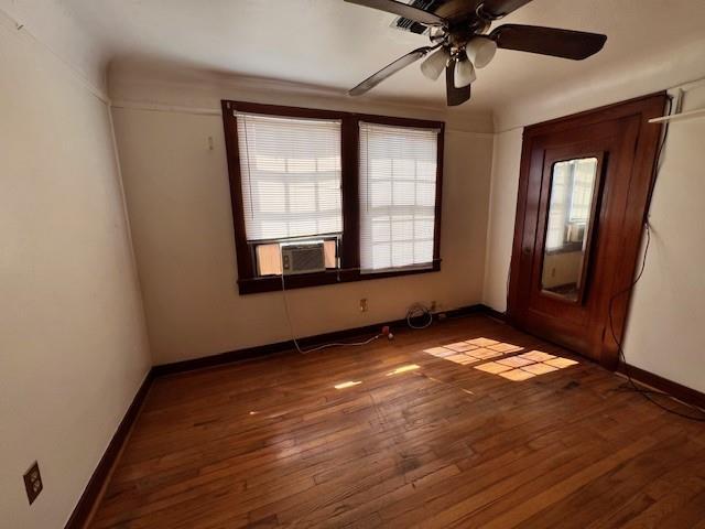 spare room with wood-type flooring, baseboards, a healthy amount of sunlight, and a ceiling fan