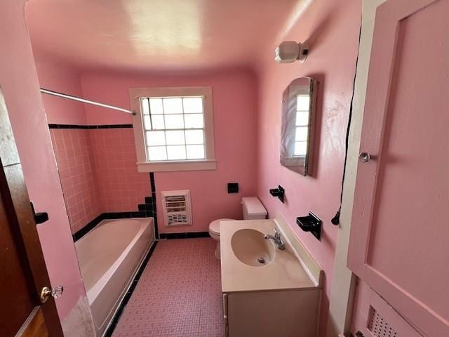 bathroom with a wealth of natural light, toilet, vanity, and heating unit