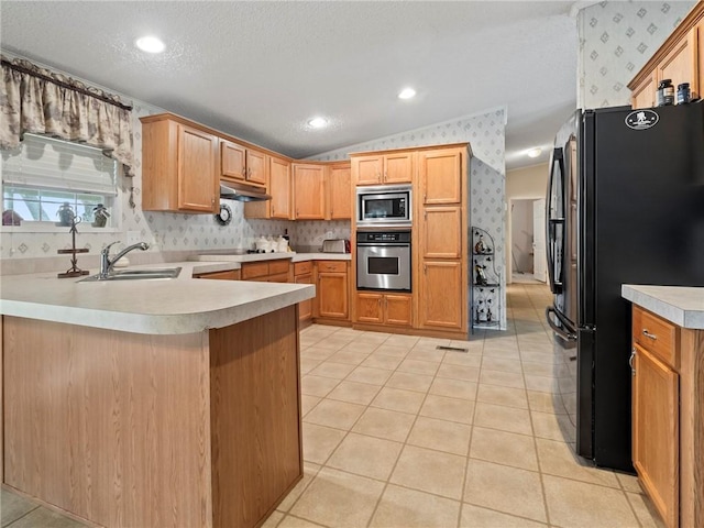 kitchen with sink, black appliances, a textured ceiling, vaulted ceiling, and kitchen peninsula