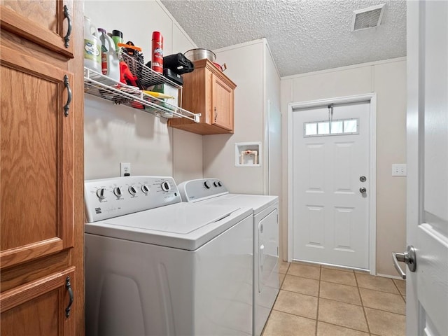 laundry room featuring independent washer and dryer, light tile patterned floors, cabinets, and a textured ceiling