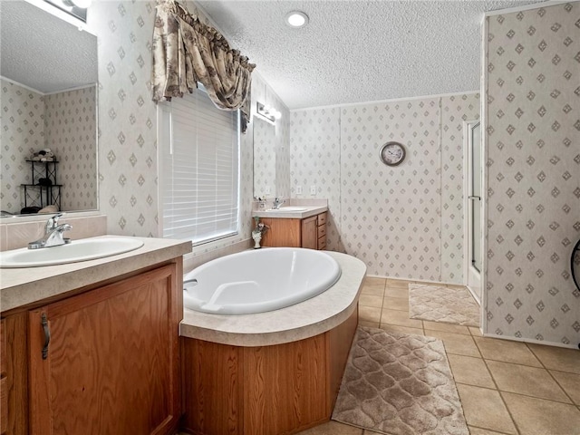 bathroom with independent shower and bath, vanity, tile patterned floors, and a textured ceiling