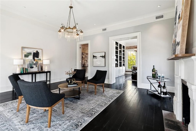 living room with crown molding, dark wood-type flooring, and a chandelier