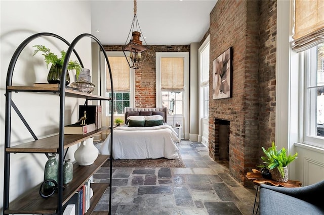 unfurnished bedroom with brick wall and a brick fireplace