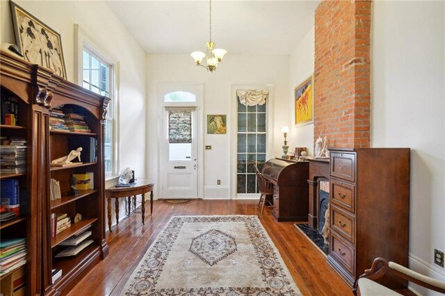 home office with an inviting chandelier and dark wood-type flooring