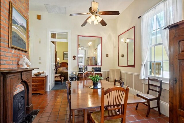 dining space featuring ceiling fan and dark tile patterned floors